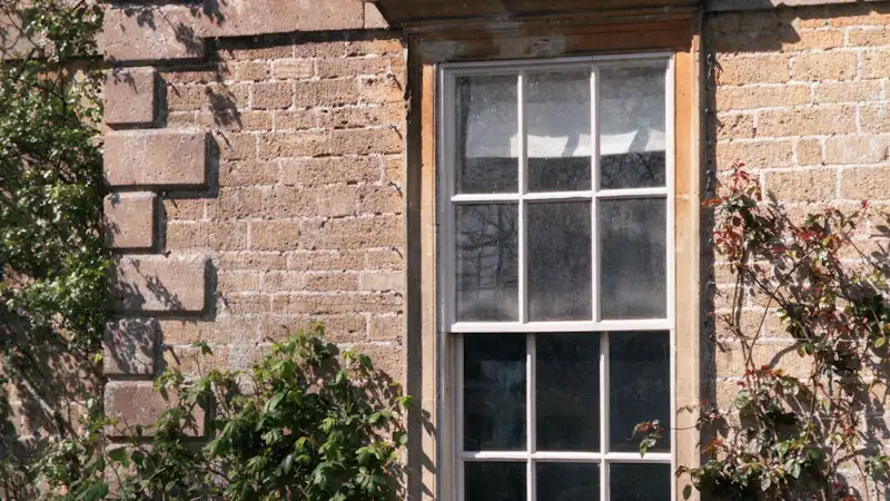 Timber sash window set in an old brick wall