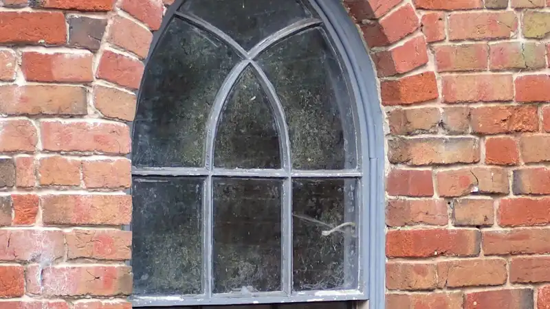 Painted timber sash window in a red brick wall